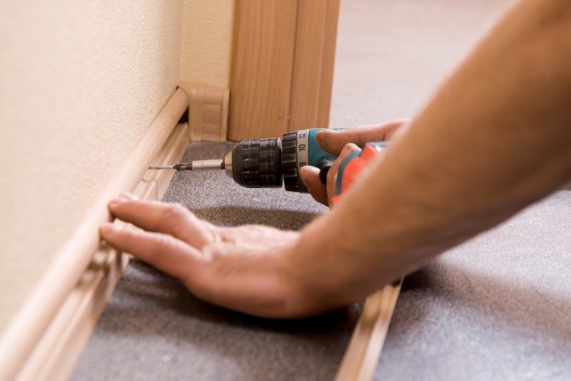 Fixing of a skirting board with a screwdriver.